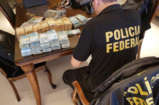 Agente da PF separa dinheiro apreendido em operação de hoje (Imagem: Divulgação)
