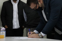 Alan Guedes assinando comprovante de doações (Imagem: Assecom)