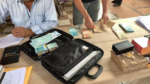Policiais recolhem documentos apreendidos durante Operação Dark Money (Imagem: Divulgação)