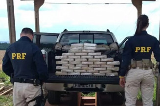 Policiais ao lado de caminhonete onde estavam tabletes de cocaína (Foto: Reprodução)