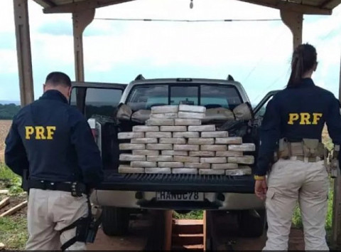 Policiais ao lado de caminhonete onde estavam tabletes de cocaína (Foto: Reprodução)