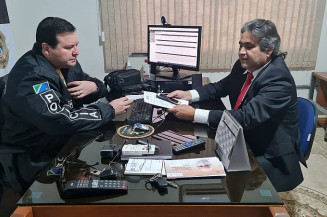 Secretário Marcelino Nunes (à direita) entrega celular a delegado (Imagem: Divulgação)