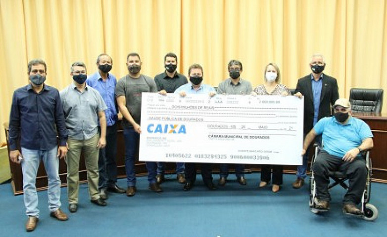 Vereadores posam com o cheque simbólico do valor que está sendo repassado ao executivo. Imagem: (Valdenir Rodrigues)